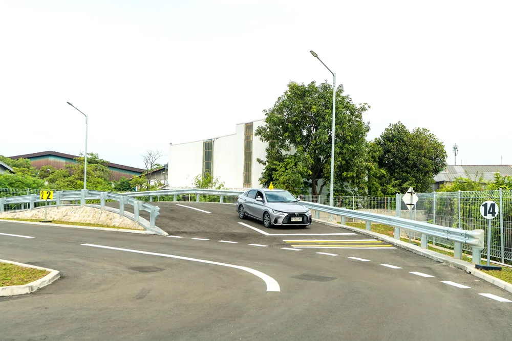 ガードレールを備えた坂道発進の練習コースと教習車