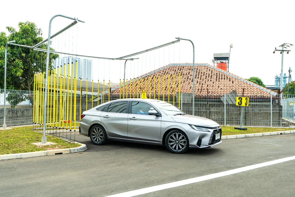 ポールで囲まれたバック駐車の練習エリアと教習車