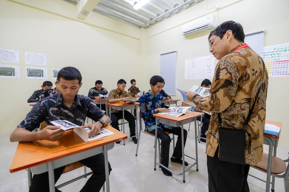 教室で指導を受けながら、教材を使って学ぶ受講生